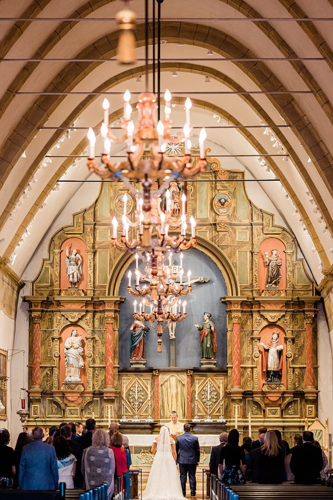 View of the ornate altar of Carmel Mission Basilica during a wedding ceremony