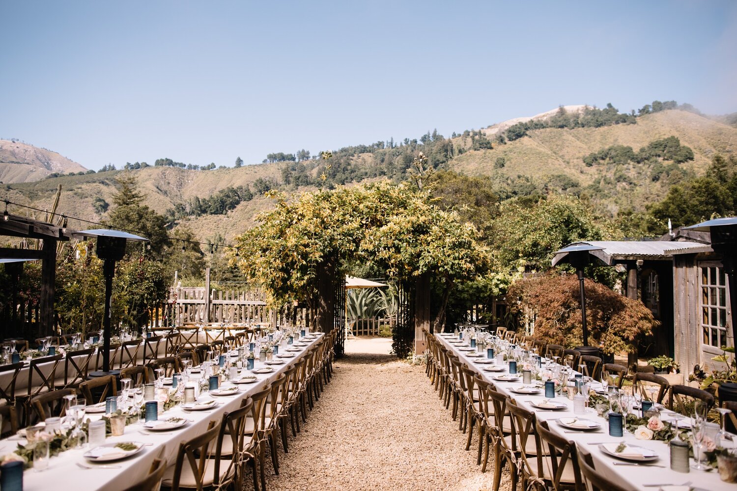 Courtyard of Loma Vista Gardens decorated by Big Sur florist for a large wedding reception with long tables lined with flower vases