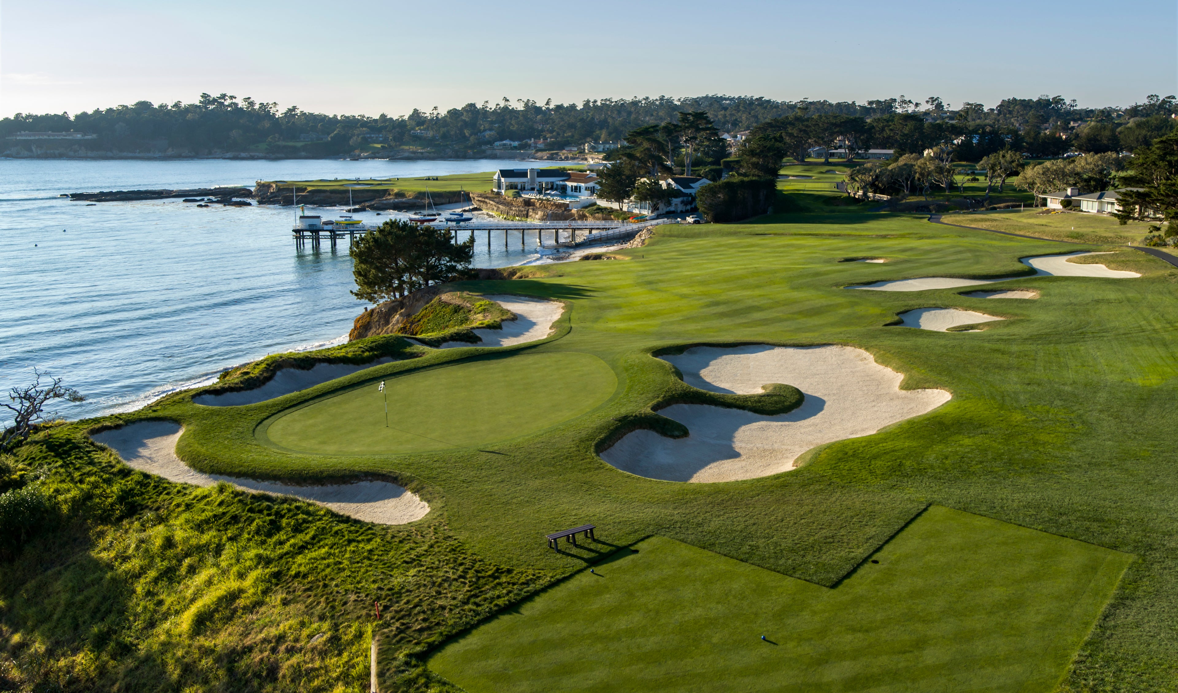 Pebble Beach golf course overlooking the oceans with perfectly manicured green grass and sand traps