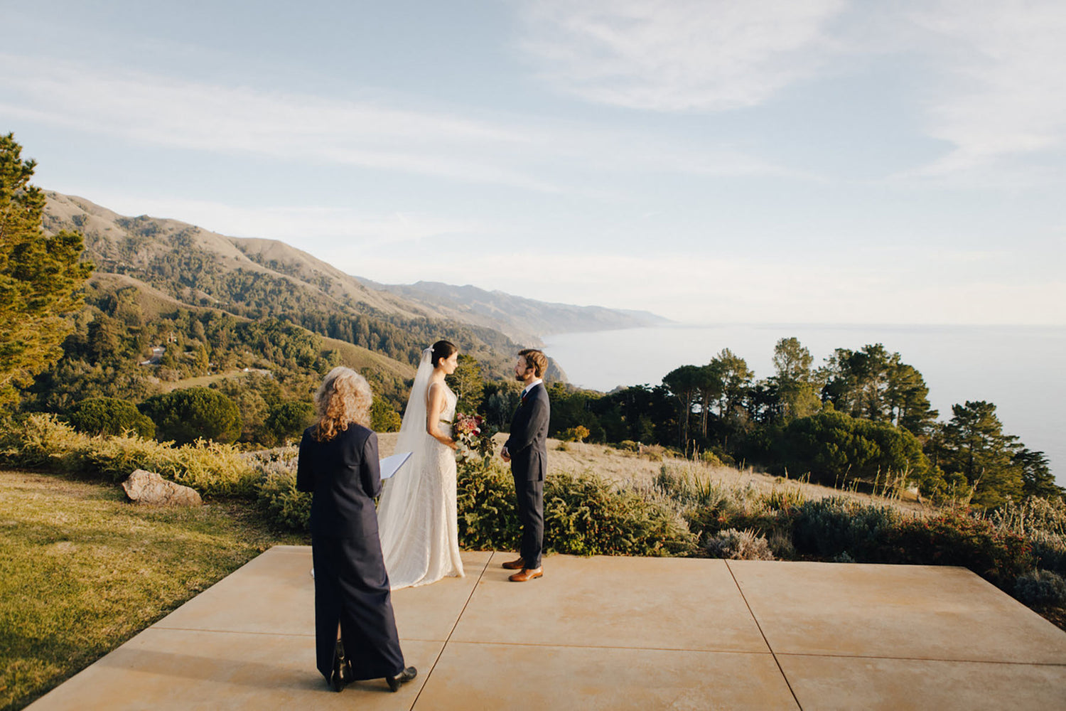 Bride holding bouquet made by Big Sur florist during elopement overlooking the ocean at Post Ranch Inn