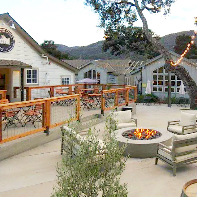 The Wine House patio with fire pit and cozy lounge chairs and views of the Santa Lucia mountains