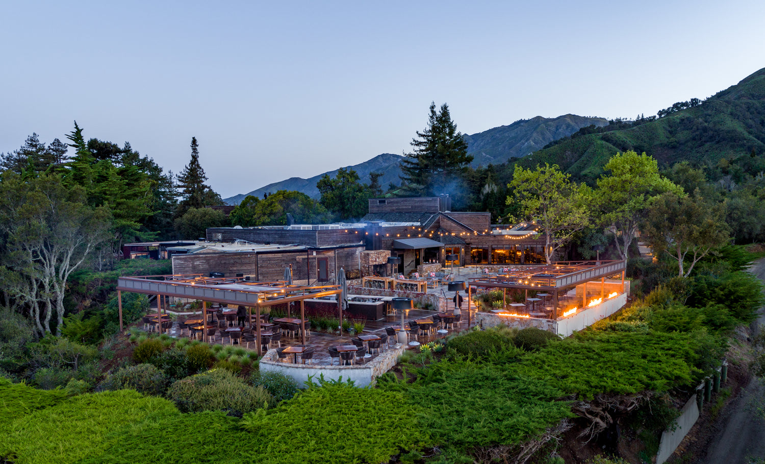 Twilight view of wedding with flowers by Big Sur florist at Ventana Big Sur resort tucked into a lush cliff setting